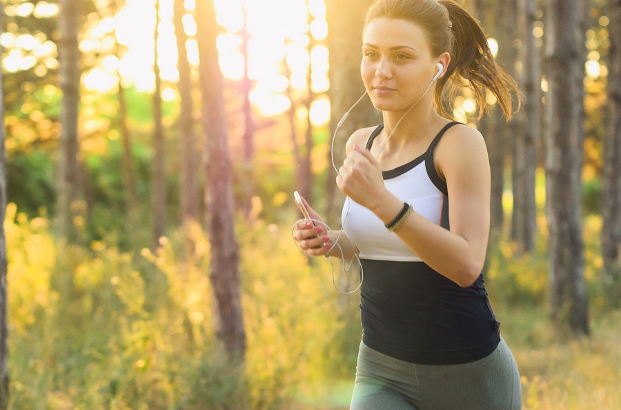 Ways to Lose Water Weight Woman Wearing Headphones While Jogging