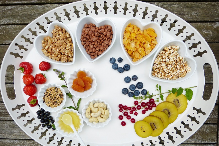 Best Whole30 Breakfast Recipes Overhead View of a Platter with Nuts and Fruits in Heart-Shaped Dishes