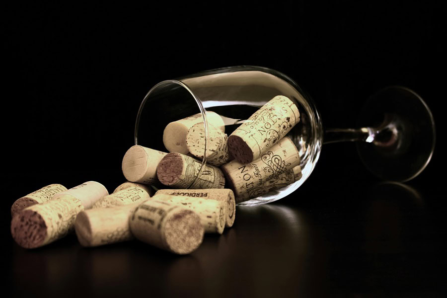 Riedel Wine Glasses Drinking Guide a Tipped Over Wine Glass Filled with Wine Corks