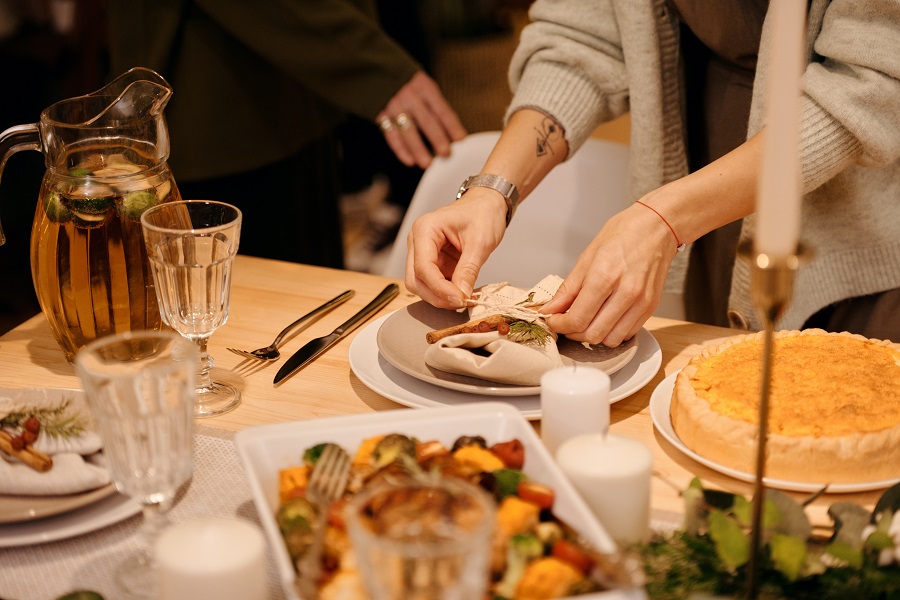 Thanksgiving Appetizers Close Up of a Table Setting with People Putting it Together