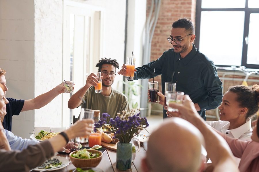 Thanksgiving Appetizers a Man Making a Toast at a Thanksgiving Dinner with Others Around the Table Raising a Glass