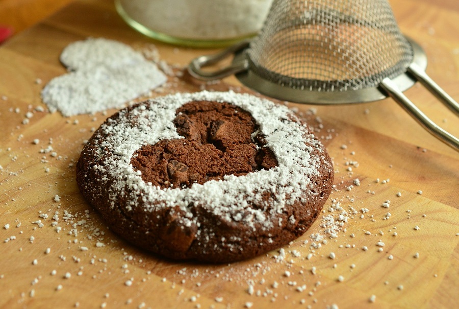 Holiday Cookie Recipes Close Up of a Chocolate Cookie with a Heart-Shaped Powder Sugar Outline