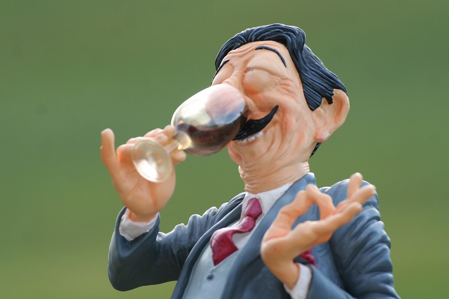 Wine Tasting Tips Small Cartoonish Figure of a Man Smelling Wine in a Glass