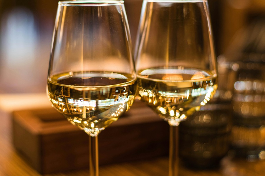 Best Wine Drinking Games to Play with Friends Close Up View of Two Wine Glasses Filled with White Wine