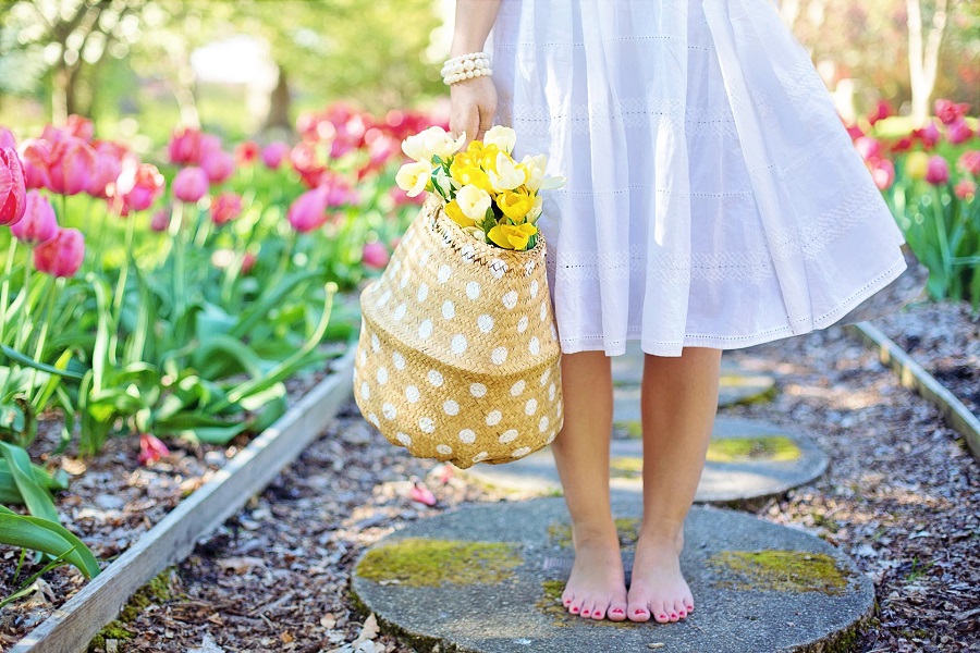 Spring Wreath Ideas for Your Front Door Close Up of a Little Girl Walking on a Stone Path Carrying a Bag of Fresh Flowers