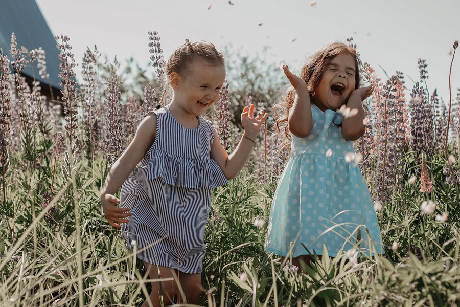 Short Quotes About Happiness To Brighten Your Day Two Little Girls Laughing and Smiling as They Stand in a Field of Tall Flowers