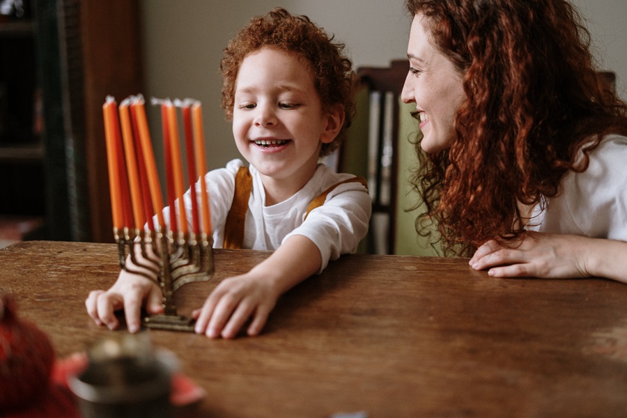 Mensch on a Bench Rules a Child and His Mother Looking at a Menorah 