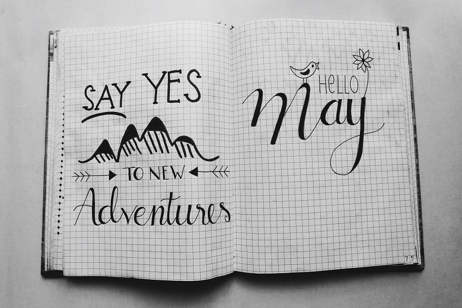 Benefits of Bullet Journaling Overhead View of an Open Bullet Journal That Says Say Yes to New Adventures