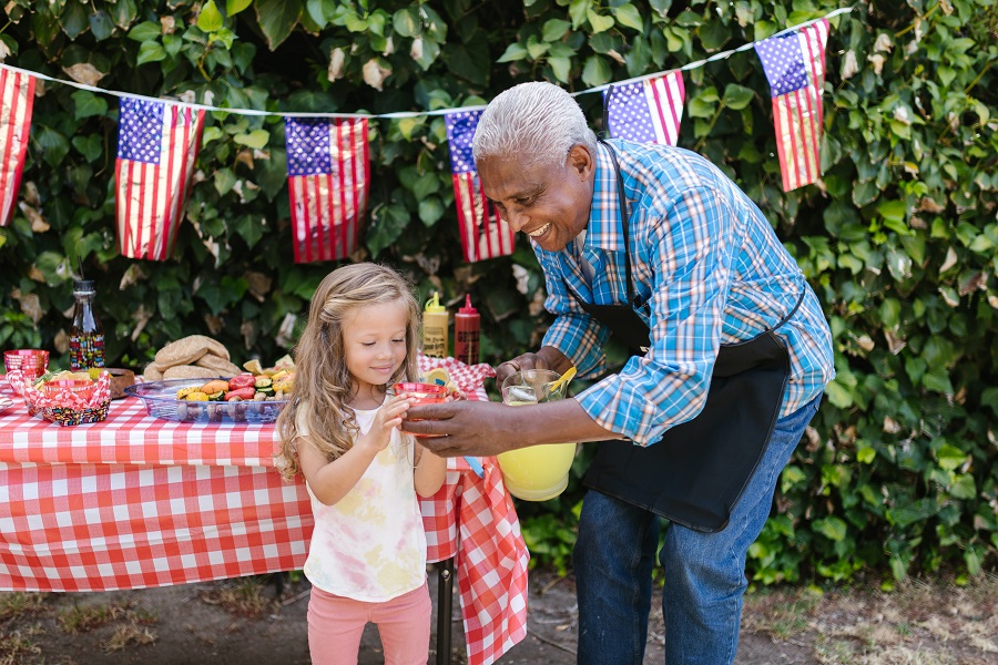 July 4th Decorations Close Up of an Older Man Handing a Drink to a Young Girl at a Fourth of July Party
