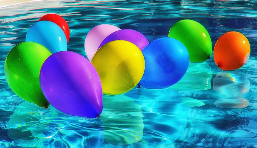 Summer Decorations for an Outdoor Party a Bunch of Balloons in Assorted Colors Floating on a Pool