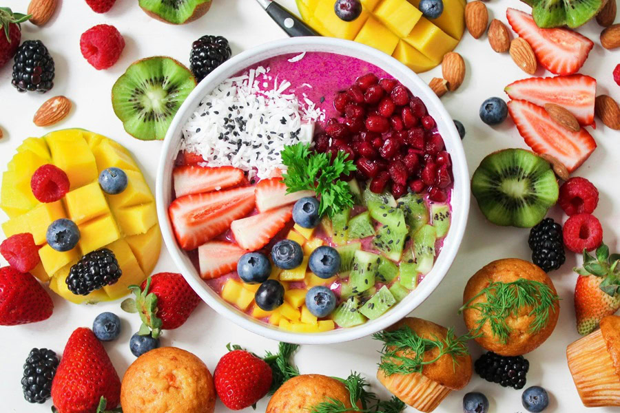 Clean Eating Breakfast Recipes for Beginners Overhead View of a Smoothie Bowl Surrounded with Fruit