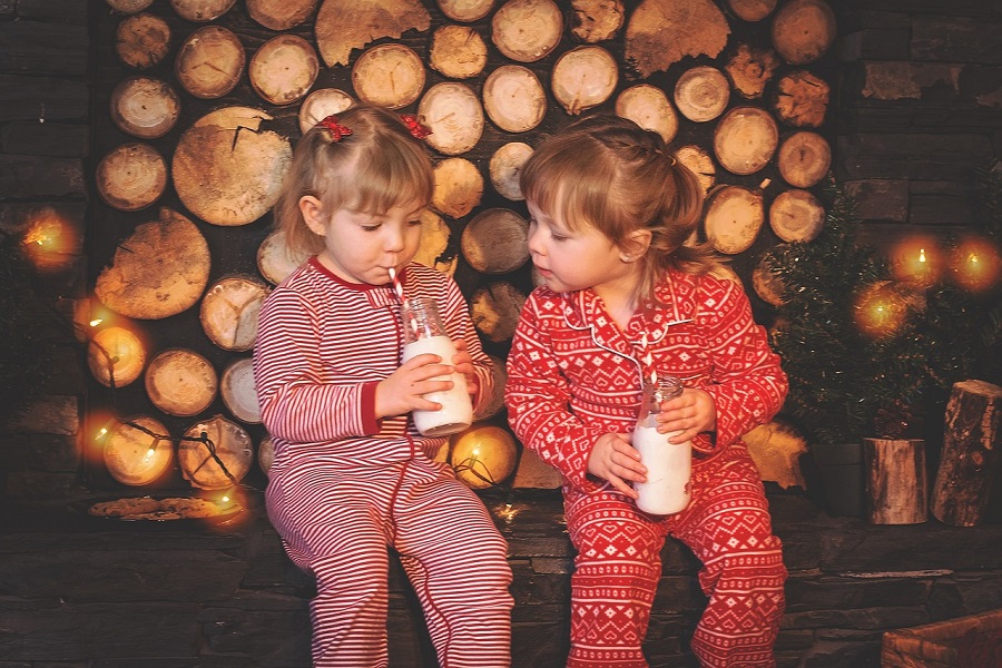 12 Days of Christmas Quotes for Kids Two Young Sisters in Christmas Pajamas, Drinking Milk 