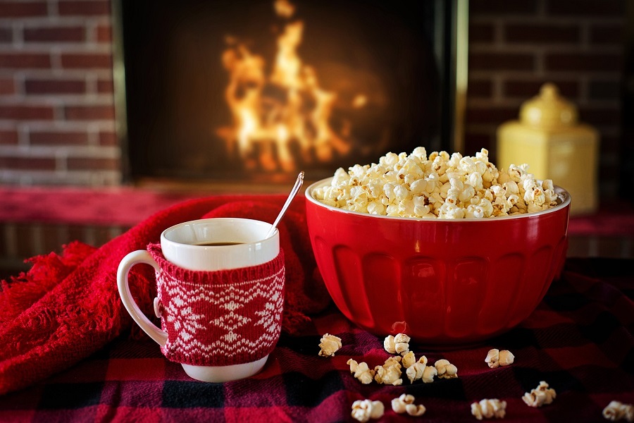 Things to Do on Christmas Morning a Red Bowl of Popcorn Next to a Cup of Hot Chocolate on a Coffee Table in Front of a Roaring Fire in a Fireplace