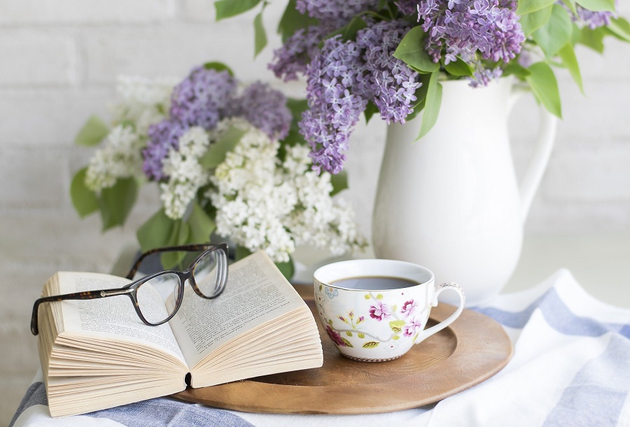 Funny Books for Adults View of an Open Book on a Small Table with Glasses, Tea, and Flowers