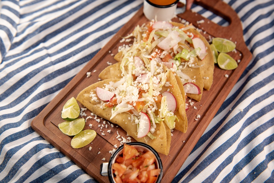 Instant Pot Carnitas Recipes a Serving Tray of Tacos with Limes and Salsa