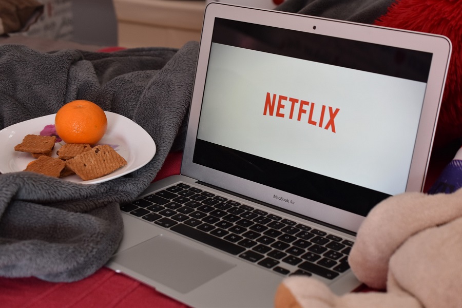 Netflix Shows to Binge Watch this Summer Close Up of a Laptop with Netflix on the Display and a Bowl of Snacks Sitting Next to it