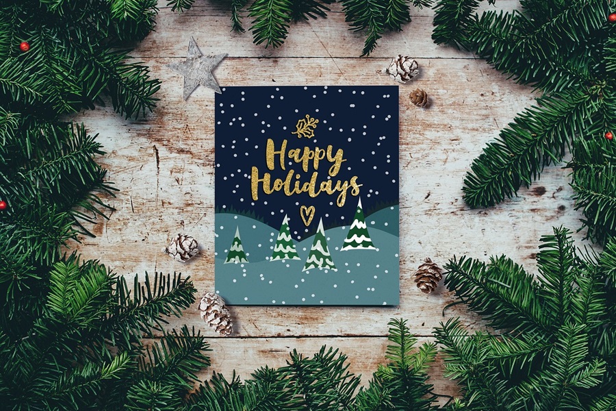 Bullet Journal Holiday Planning Layouts a Journal That Says Happy Holidays on a Wooden Surface with Garland Surrounding It