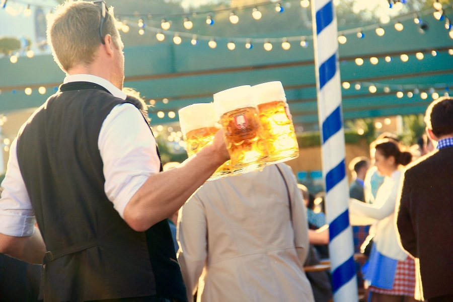 Craft Beer and Food Pairing Tips a Man Carrying Beer Glasses Filled with Beer Through a Festival Setting