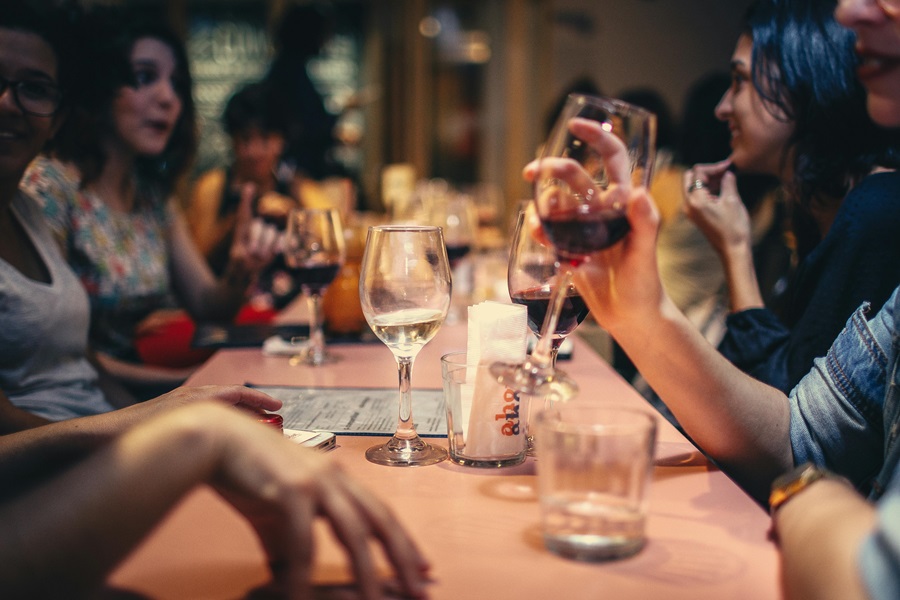 Wine Etiquette Tips a Person Drinking Wine at a Table in a Restaurant Filled with People