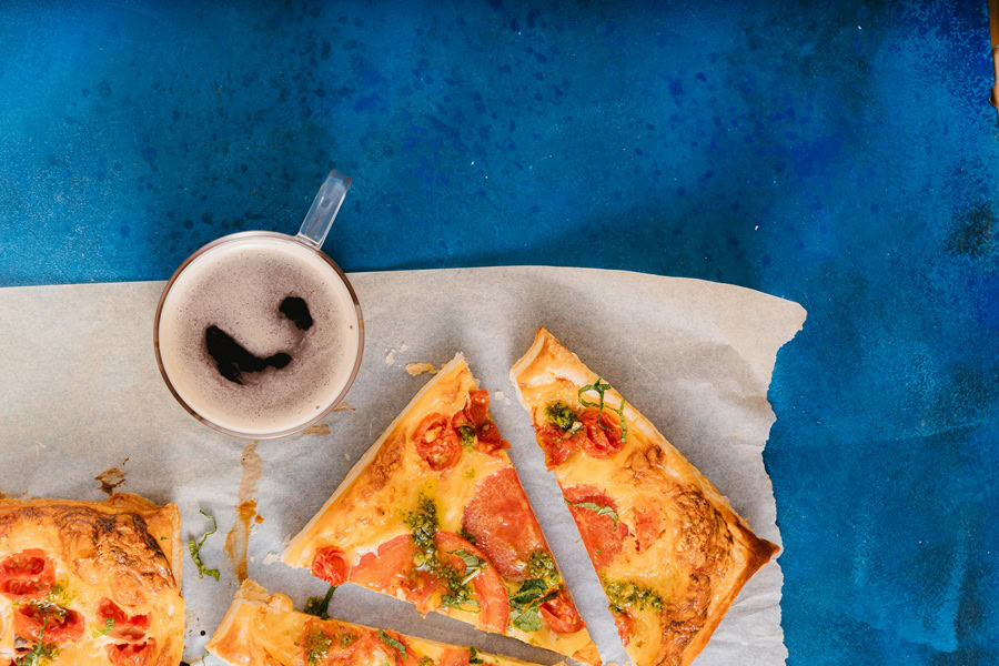 Best Breakfasts For Single Guys Sliced Pizza on a Napkin Next to a Cup of Coffee