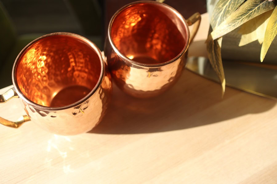 Best Things to Know About Moscow Mules Close Up of Two Copper Mugs on a Wooden Surface