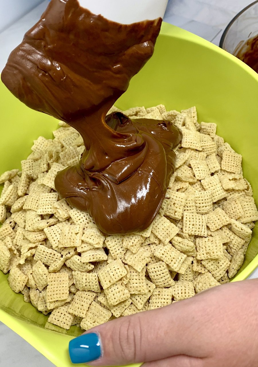 Halloween Puppy Chow Recipe Chex Mix in a Bowl with Chocolate Being Poured Over It