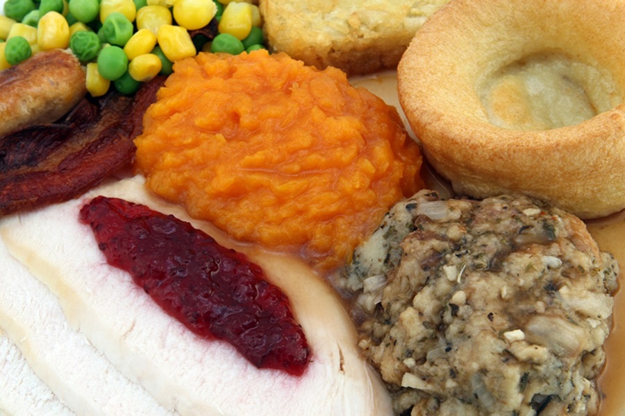 Instant Pot Cranberry Sauce Recipes Close Up of a Thanksgiving Plate with Cranberry Sauce on the Turkey and Stuffing, Veggies, and Cornbread
