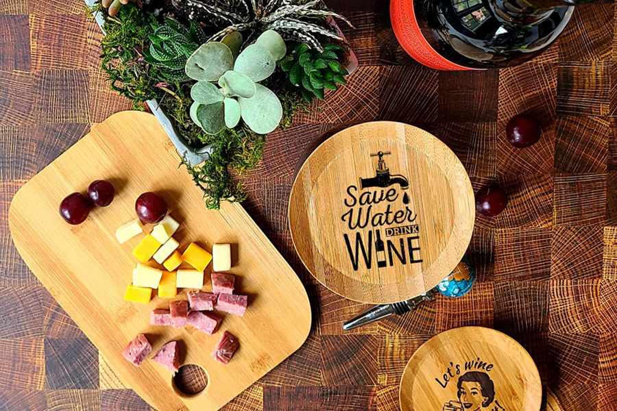 Best Wine Glass Toppers a Topper on a Wine Glass That Says, "Save Water, Drink Wine" Next to a Charcuterie Board with Cheese, Grapes, and Meat