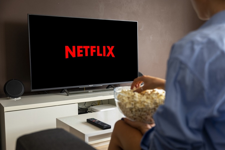 Best Netflix Series for Teens a Person Sitting Down with a Bowl of Popcorn Watching Netflix