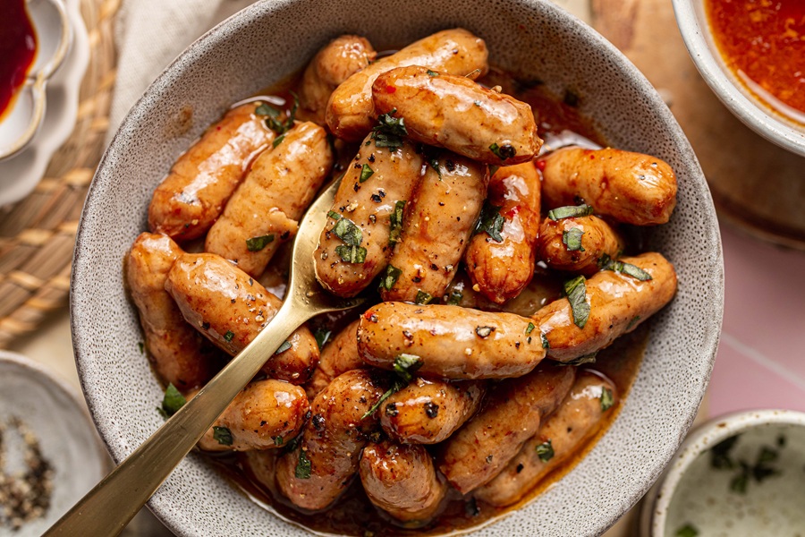 Crockpot Little Smokies Party Food Recipes Close Up of Grape Jelly BBQ Sauce Little Smokies in a Bowl with a Small Fork