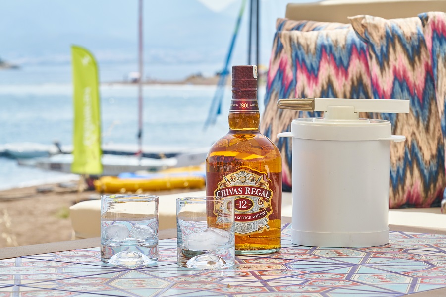Easy Whiskey Drinks a Whiskey Bottle and Two Glasses Sitting on a Table at a Beach