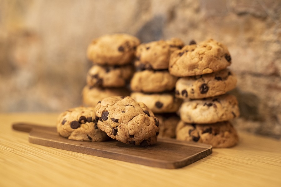 Best Chocolate Chip Cookie Recipes Two Cookies on a Serving Plate with Three Stacks of Cookies Behind It