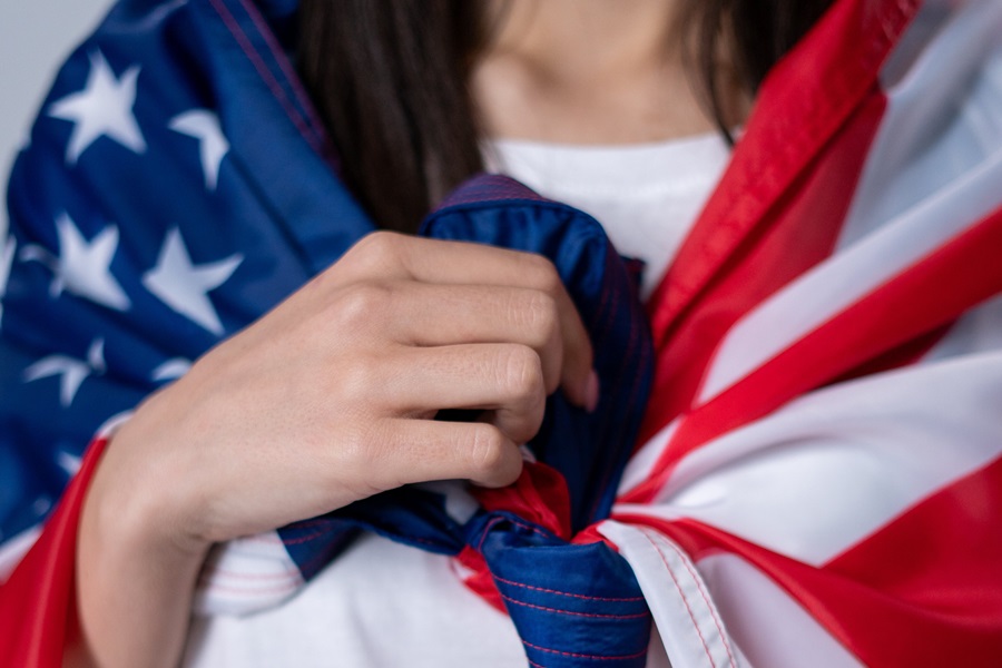 Best Red White and Blue Nails Close Up of a Woman's Hand Clutched Against Her Chest, Holding an American Flag Around Her self Like a Cape