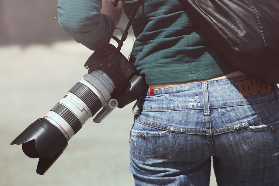Photography Poses to Up your Photo Game View of a Person's Back with a Big Camera On Their Shoulder