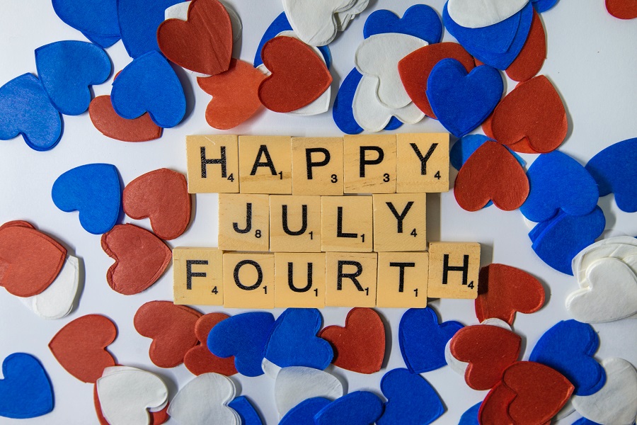 Fourth of July Facts to Know Overhead View of Letter Tiles Spelling Out "Happy July Fourth" 