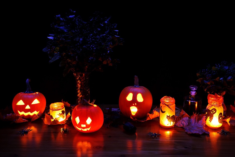 Halloween Decorations Jack O Lanterns with Lit Candles Inside Them Sitting Outside at Night