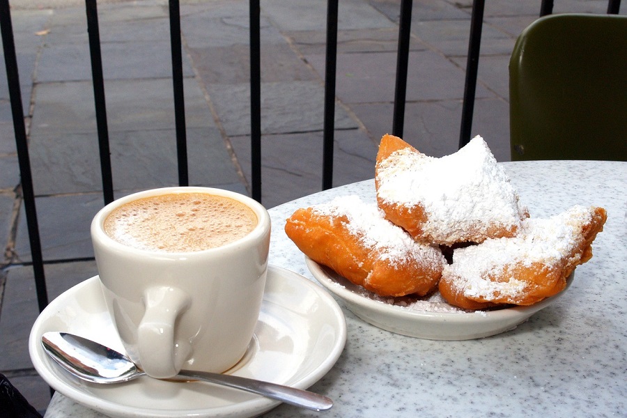 Tips for Visiting New Orleans in Fall Close Up of a Plate of Beignets and a Cup of  Coffee on a Table Outside