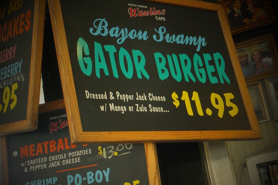 Tips for Visiting New Orleans in Fall Close Up of a Restaurant Sign Selling Gator Burgers for $11.95