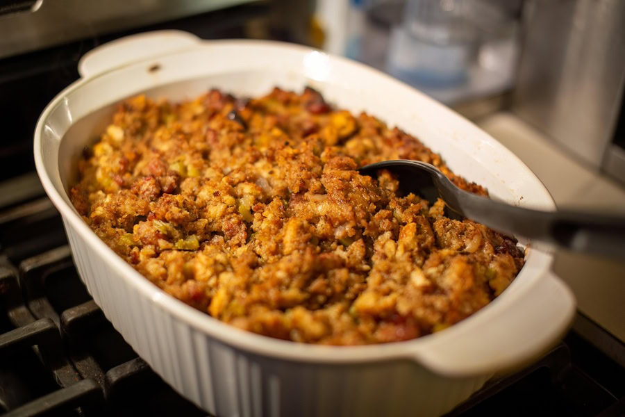 Best Thanksgiving Stuffing Recipes Close Up of Stuffing in a Baking Dish with a Spoon