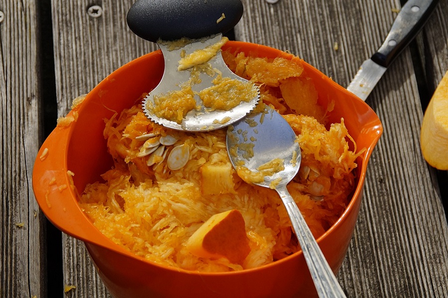 DIY Pumpkin Decorating Ideas Close Up of a Bucket of Pumpkin Guts with Carving Tools Inside