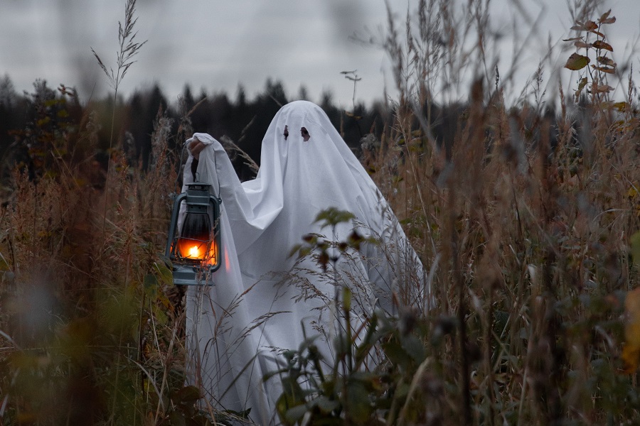 Halloween Cocktails with Whiskey a Ghost Walking Around a Field Holding a Lantern