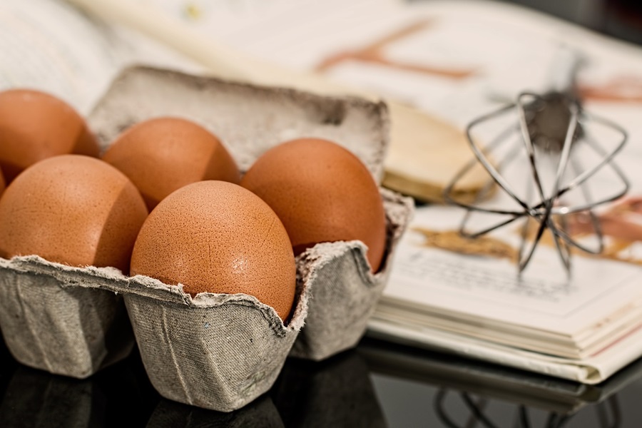 Instant Pot Egg Recipes to Start your Day a Small Carton of Eggs Next to a Cook Book and a Whisk Stand Mixer Attachment