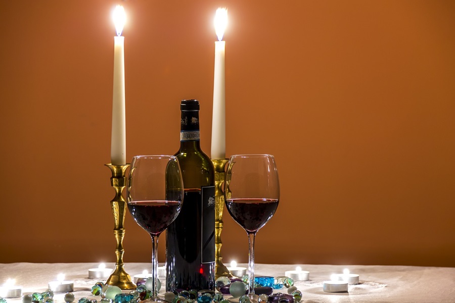 Best Date Night Recipes to Make Together Two Glasses of Red Wine on a Table with Two Lit Candles
