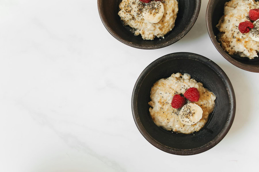 Best Overnight Oats in a Jar Recipes Three Small Black Bowls of Oats Topped with Bananas and Strawberries