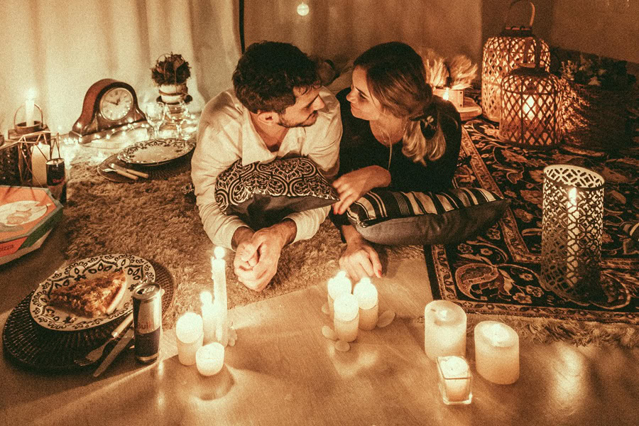 Easy Date Night Recipes a Couple Laying Together on a Floor With Lit Candles In Front of Them