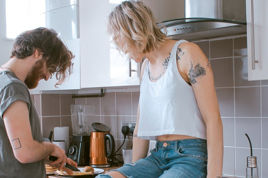 Easy Date Night Recipes a Man Cooking with a Woman Sitting on the Counter Next to The Stove Smiling