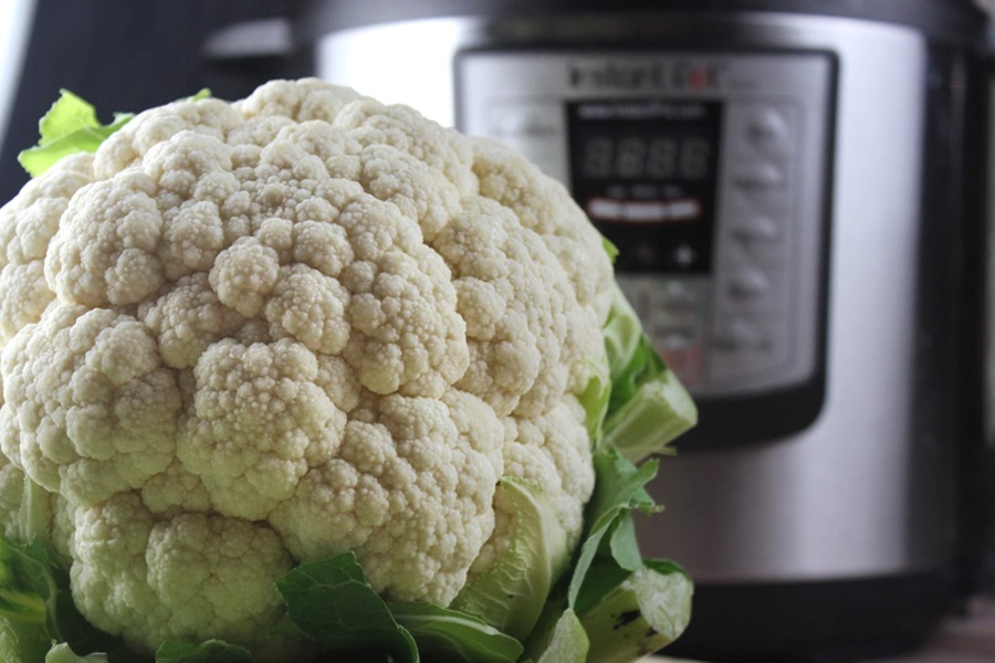 How to Use an Instant Pot Close Up of Cauliflower in Front of an Instant Pot