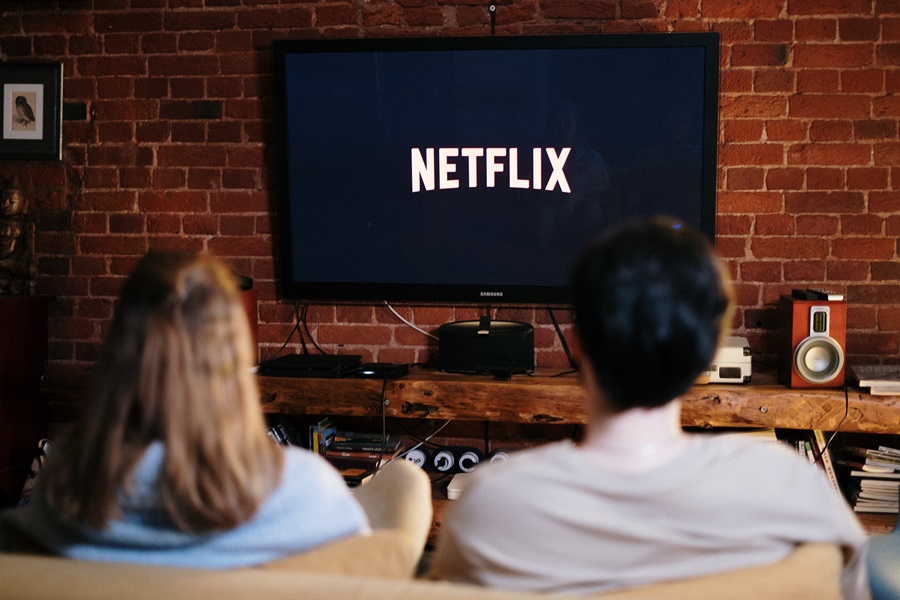 Netflix Shows to Binge Watch as a Couple View of a Couple Watching TV from Behind