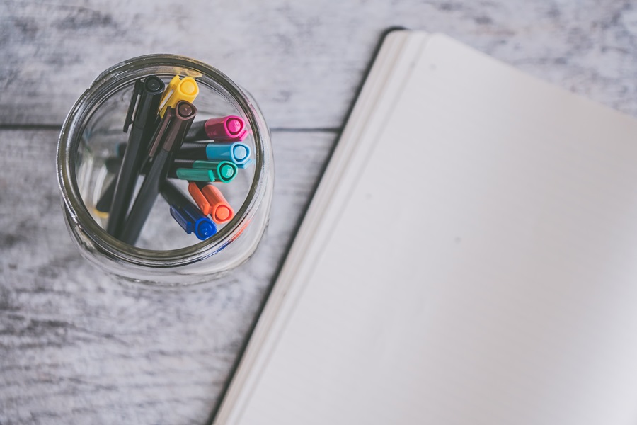 How to Set up your Bullet Journal for the New Year an Open and Empty Bullet Journal Next to a Small Cup of Pens