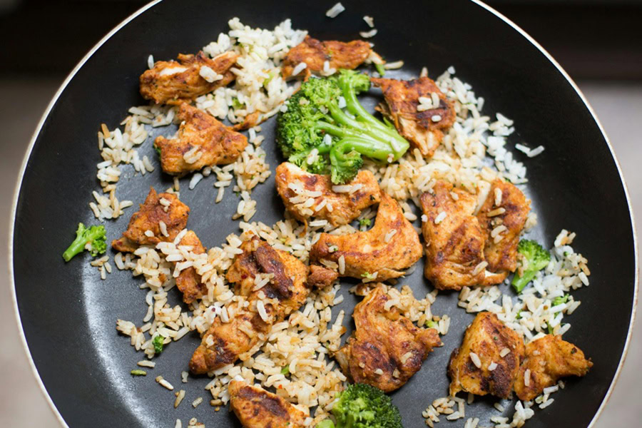 Clean Eating Recipes with Chicken Chicken and Rice Cooking in a Frying Pan